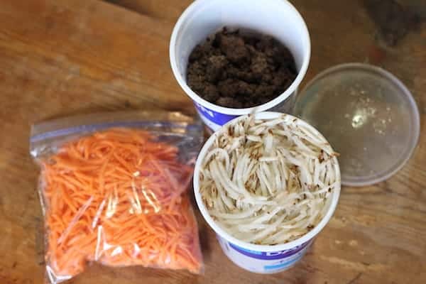 Image shows two cups and a plastic bag of ingredients on a table