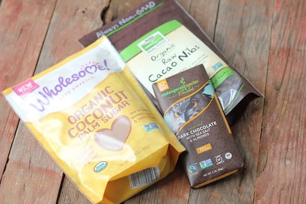 Photo shows a bag of coconut palm sugar, and raw cacao nibs on a table.