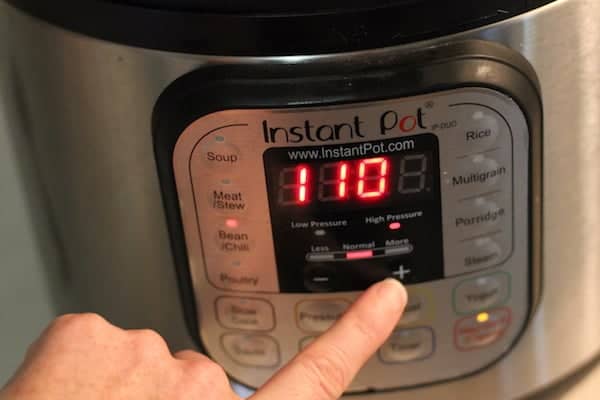 Image shows a hand adjusting the pressure on the outside of an Instant Pot