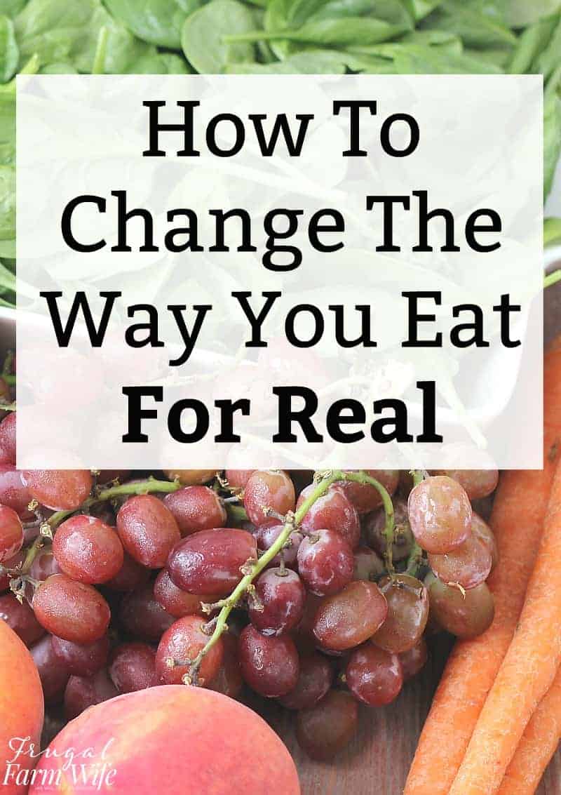 Image shows a variety of fruits and vegetables piled together, including grapes, carrots, spinach and apples. Text overlay reads "How to Change the Way You Eat for Real"