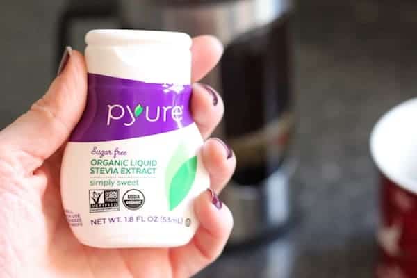 Photo shows a hand holding a bottle of stevia extract