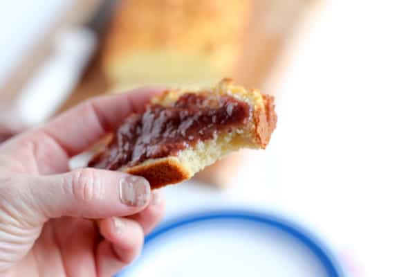 A hand holds a slice of coconut flour bread with spread