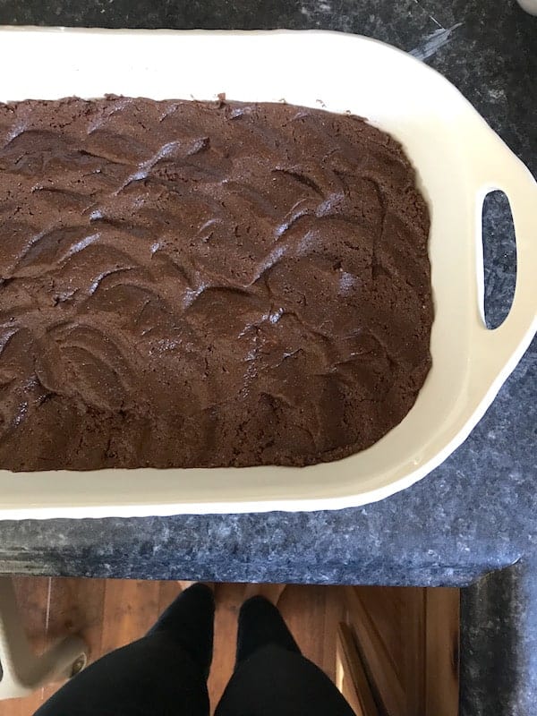 Image shows the cake layer pressed into a pan for the gooey cake 