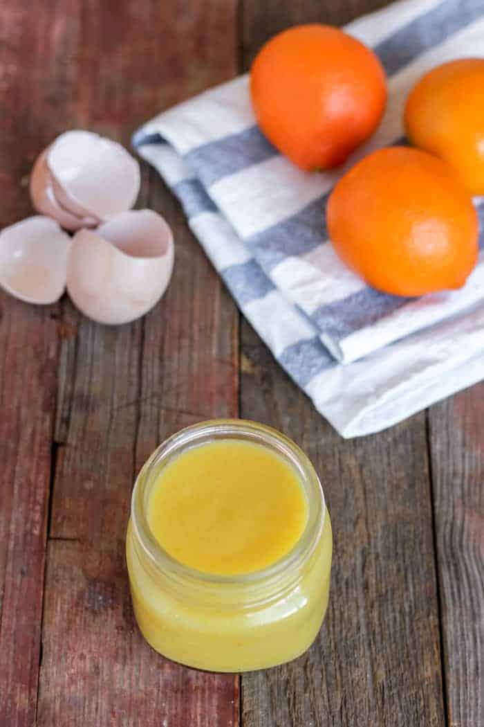 Image shows a jar on a table, with oranges and egg shells sitting nearby