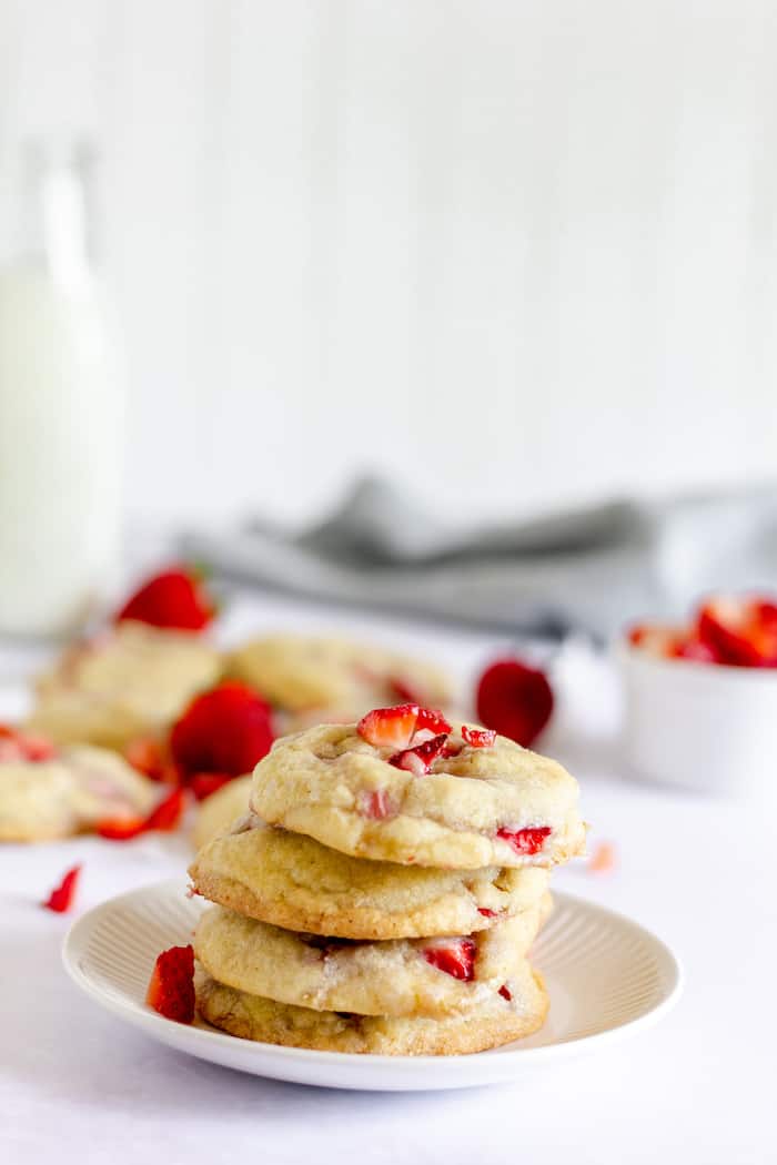 Image shows a pile of strawberry chunk cookies on a white plate