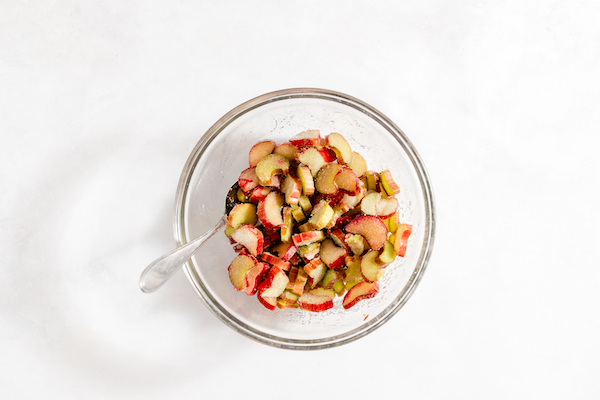 A bowl of rhubarb, sugar, and lemon juice mixed together.