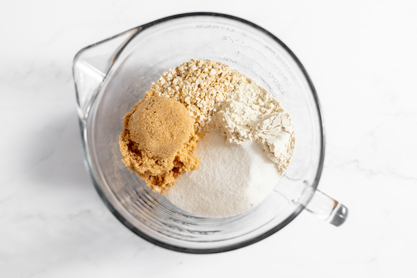 Image shows a glass mixing bowl, photographer from above with the dry ingredients for the crisp poured into it. 