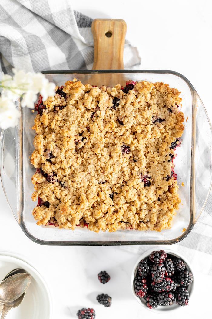 Image, taken from above, shows the baked blackberry crisp sitting on a countertop. 