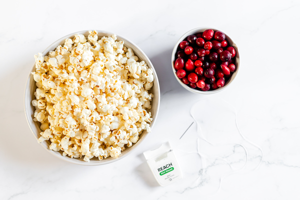 Images shows the supplies for making a popcorn and cranberry garland for your Christmas tree.