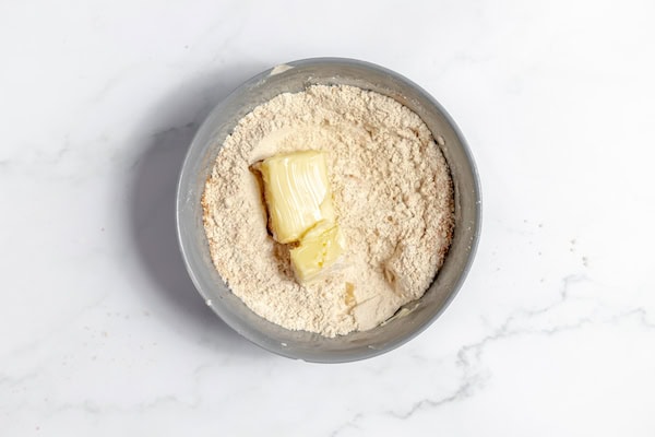 Image, taken from above, shows a large bowl with the ingredients for streusel topping ready to be mixed together.