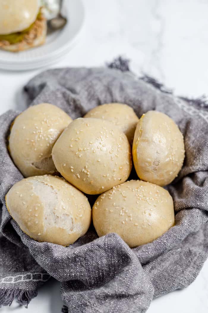 Image shows a napkin lined basket full of sourdough hamburger buns