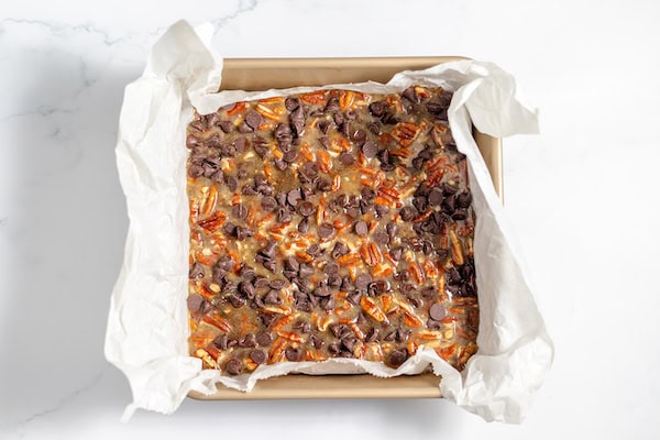 Image, taken from above, shows the filling poured into the pan with the shortbread crush, and sprinkled with chocolate chips.