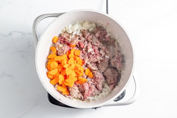 browning sausage, onions, and carrots