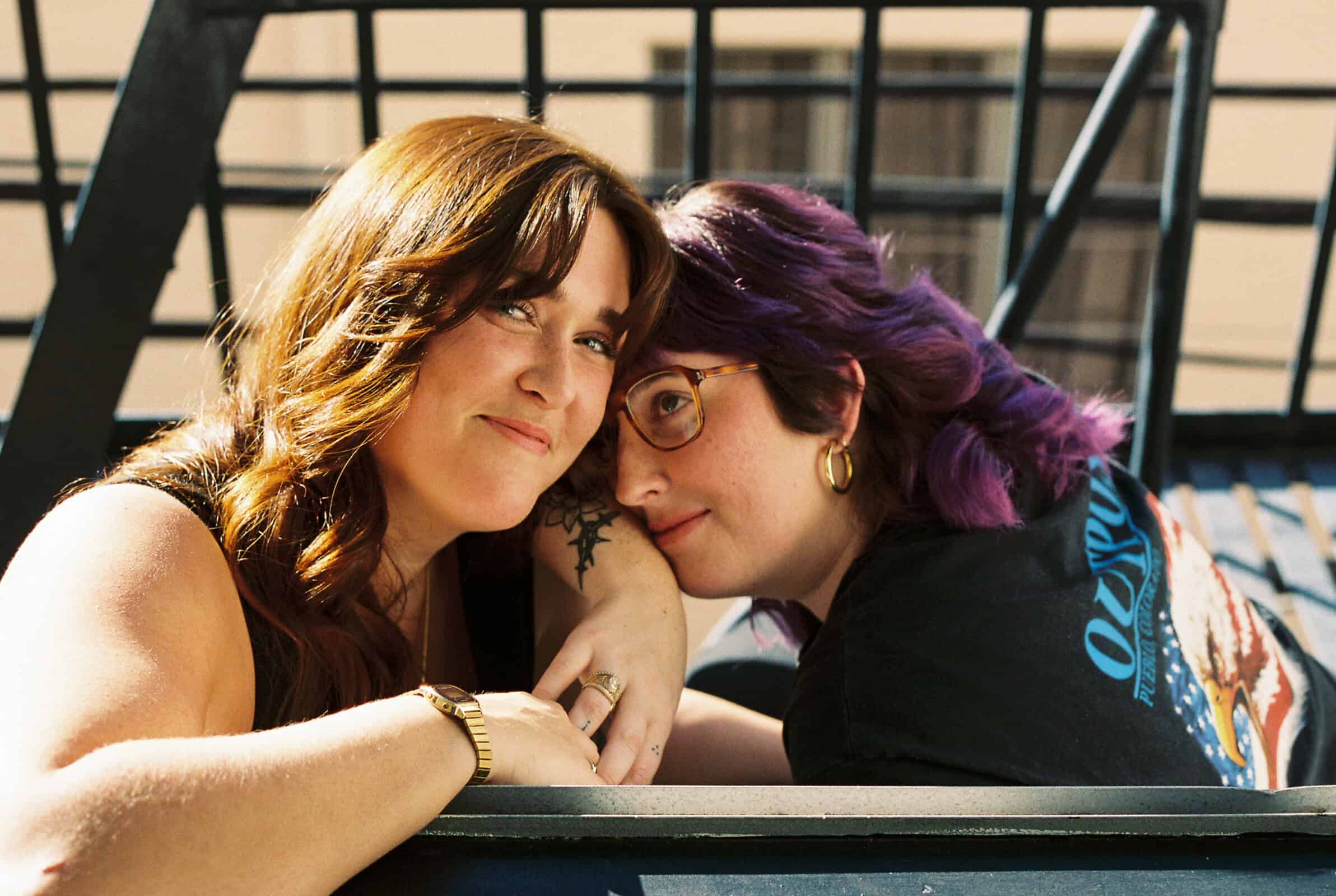 queer femme couple on fire escape in downtown los angeles