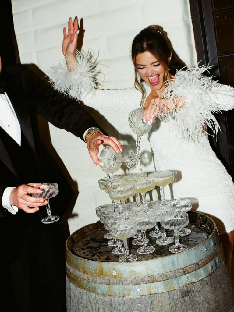 Romantic film wedding photo of a bride and groom champagne tower at Morgan Estate in Temecula