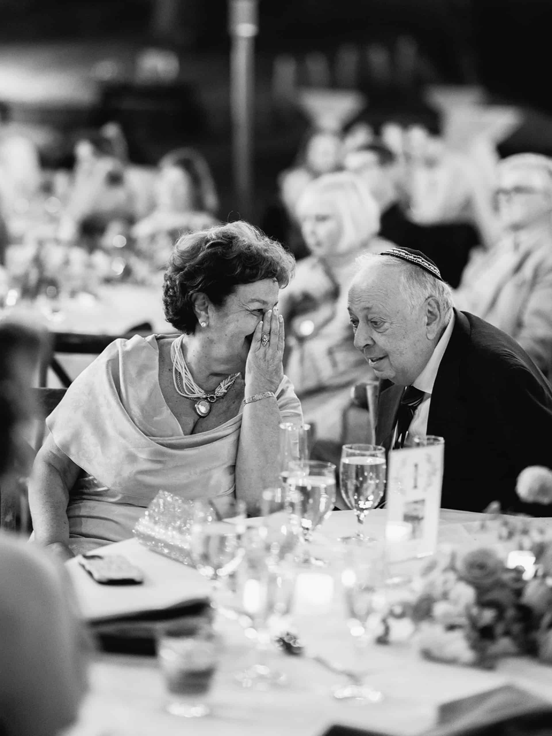 grandparents whispering during speeches at a wedding reception in temecula california