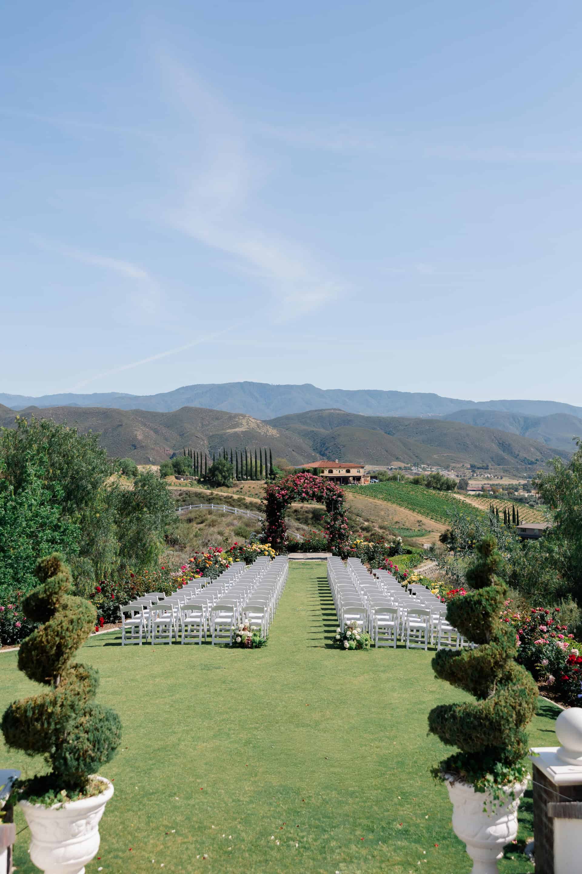 Beautiful outdoor wedding setup with rows of chairs and scenic mountain backdrop.