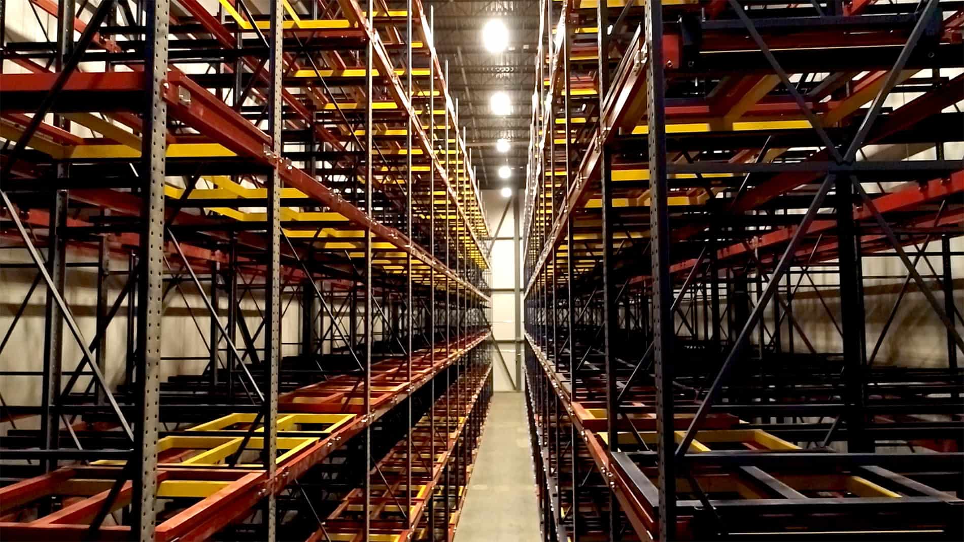 A photo of a long row of tall, empty metal racks closely lining the sides of the narrow walkway. The Ruprecht Meat Company Processing Facility expansion was completed by Keeley Construction, Inc.
