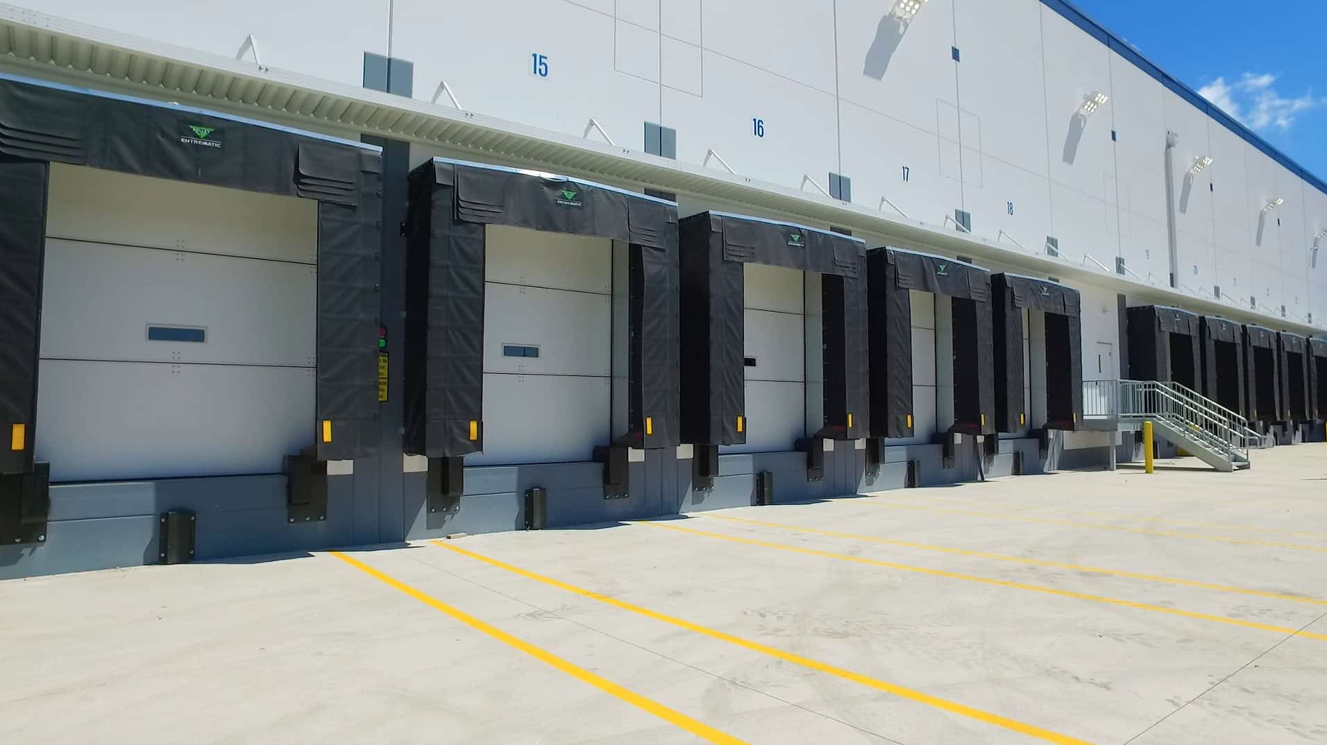 An angled view of one side of the third Preferred Freezer Services facility built by Keeley Construction shows ten loading bay doors ready for trucks.