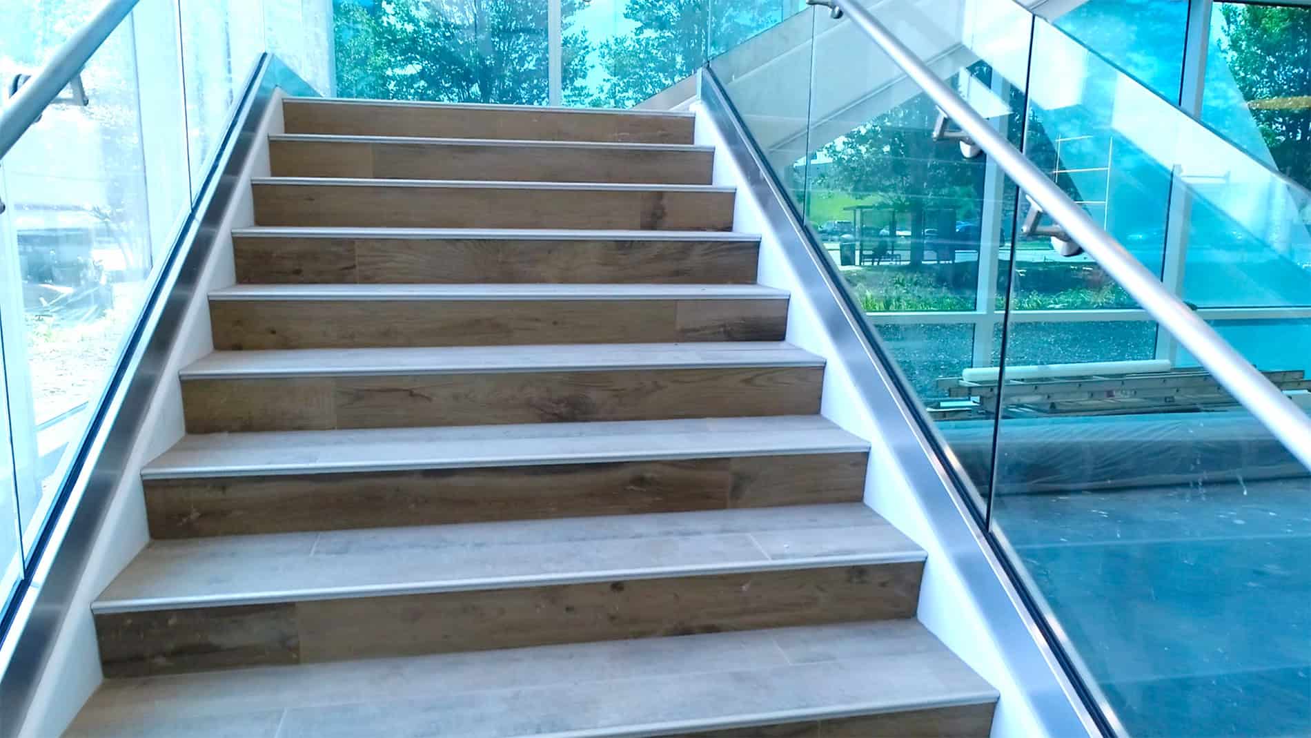 A closeup of a staircase with glass enclosures, found in the newly created DHL Americas Innovation Center built by Keeley Construction.