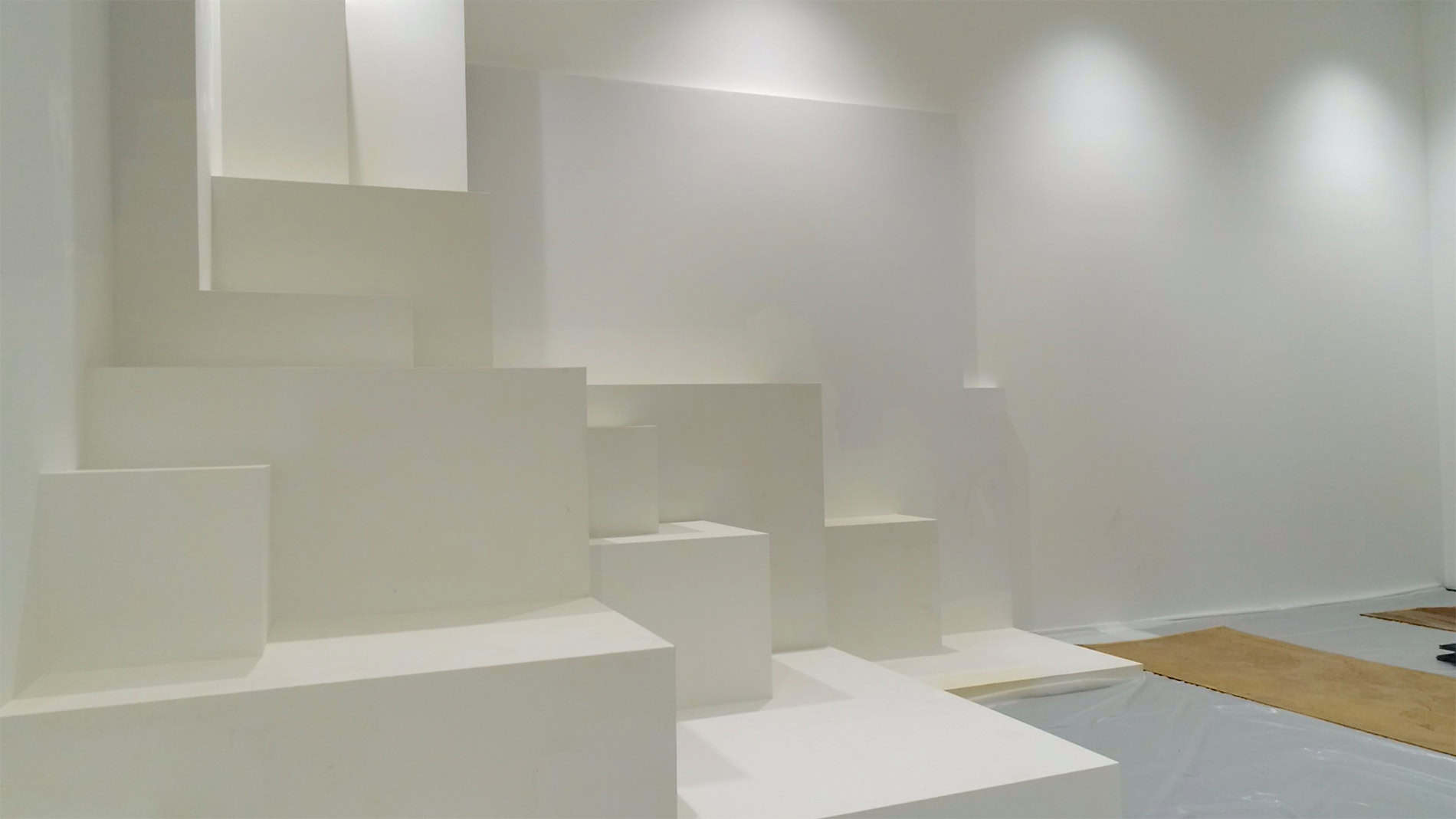 A white room with white staggered cubes in the corner.