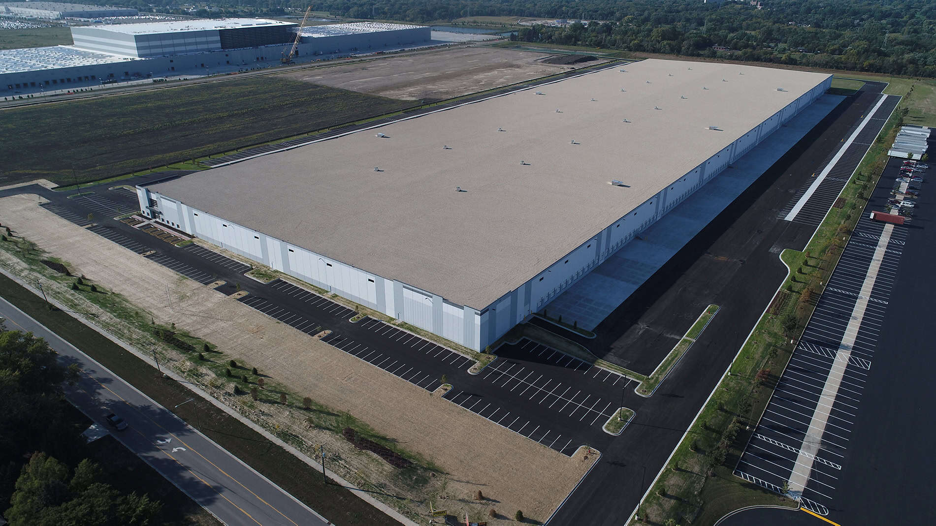 A view from above a new DHL warehouse and distribution center. Manicured fields surround the building.