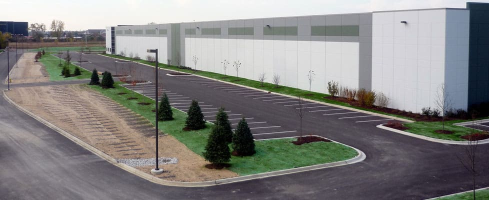 A newly made parking lot lines the length of the modern white and grey 952,675 SF M. Block and Sons' new development, constructed by Keeley Construction, Inc.