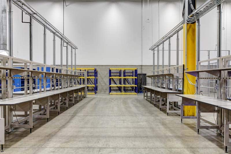 A look down the aisle of Zones’ giant industrial room flanked by empty benches and shelves.