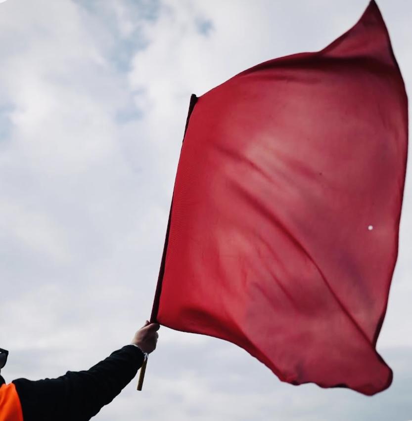 Rote Flagge bei Karnevalsveranstaltung in Köln, Symbol für Karnevalstradition.