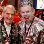 Zwei Karnevalisten in bunten Kostümen, einer als Clown, feiern beim Karneval.