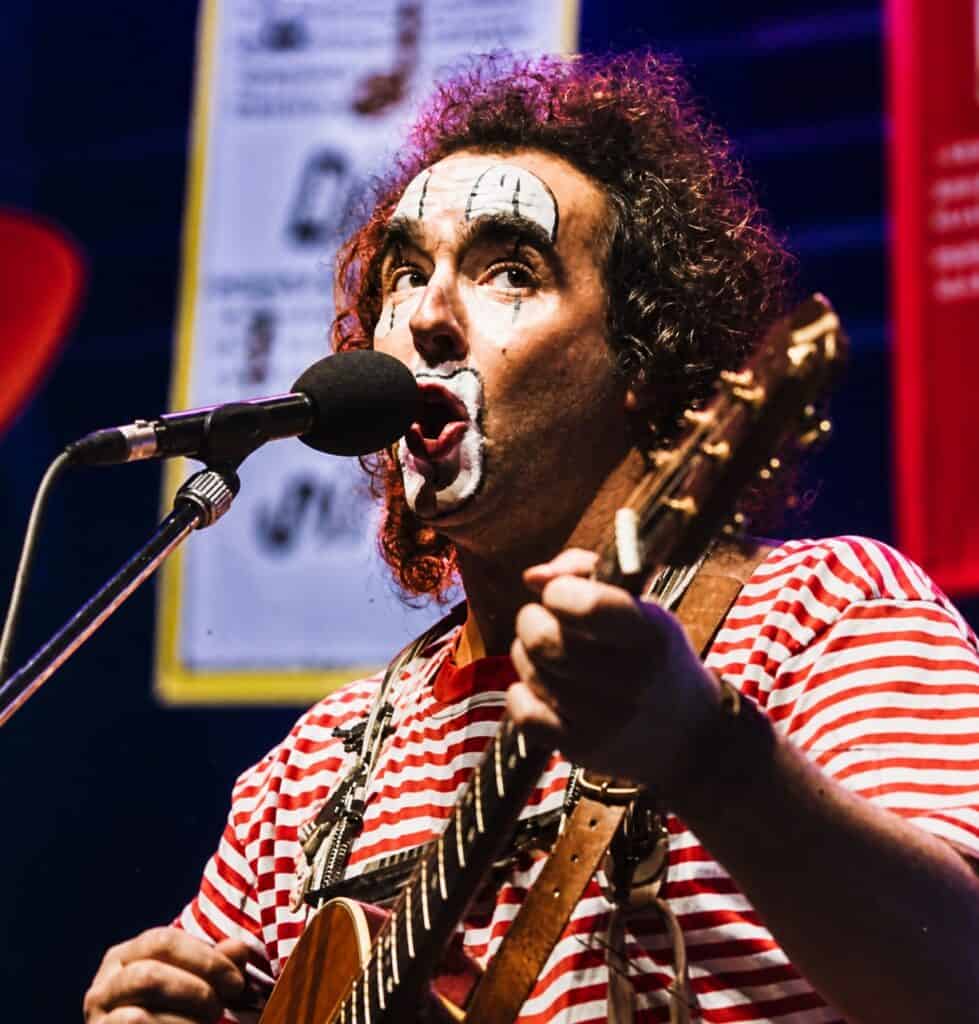 Karnevalskünstler singt und spielt Gitarre bei Karnevalsveranstaltung.