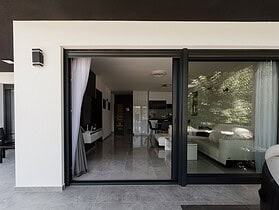 Baie vitrée rénovée ouvrant un salon moderne sur une terrasse