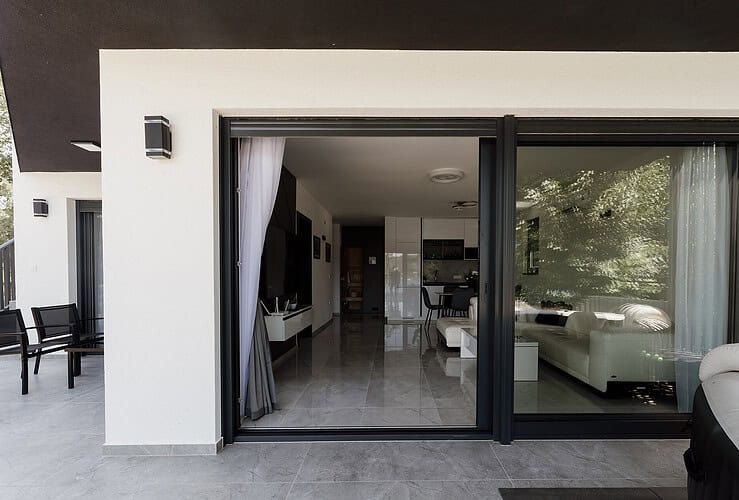 Baie vitrée rénovée ouvrant un salon moderne sur une terrasse