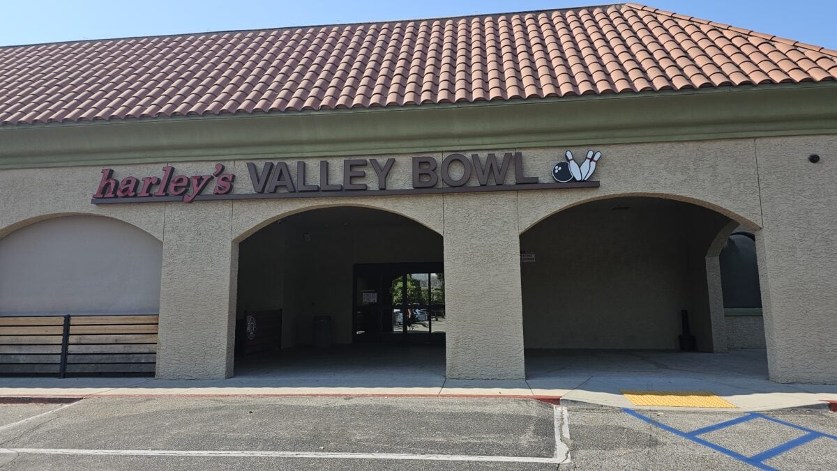 Exterior of Harleys Valley Bowl with a tiled roof and an arched entrance. Bowling pins and ball icon included in the signage.