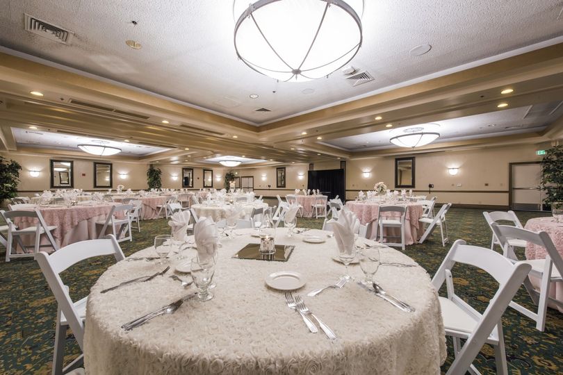 A large ballroom with white tables and chairs.