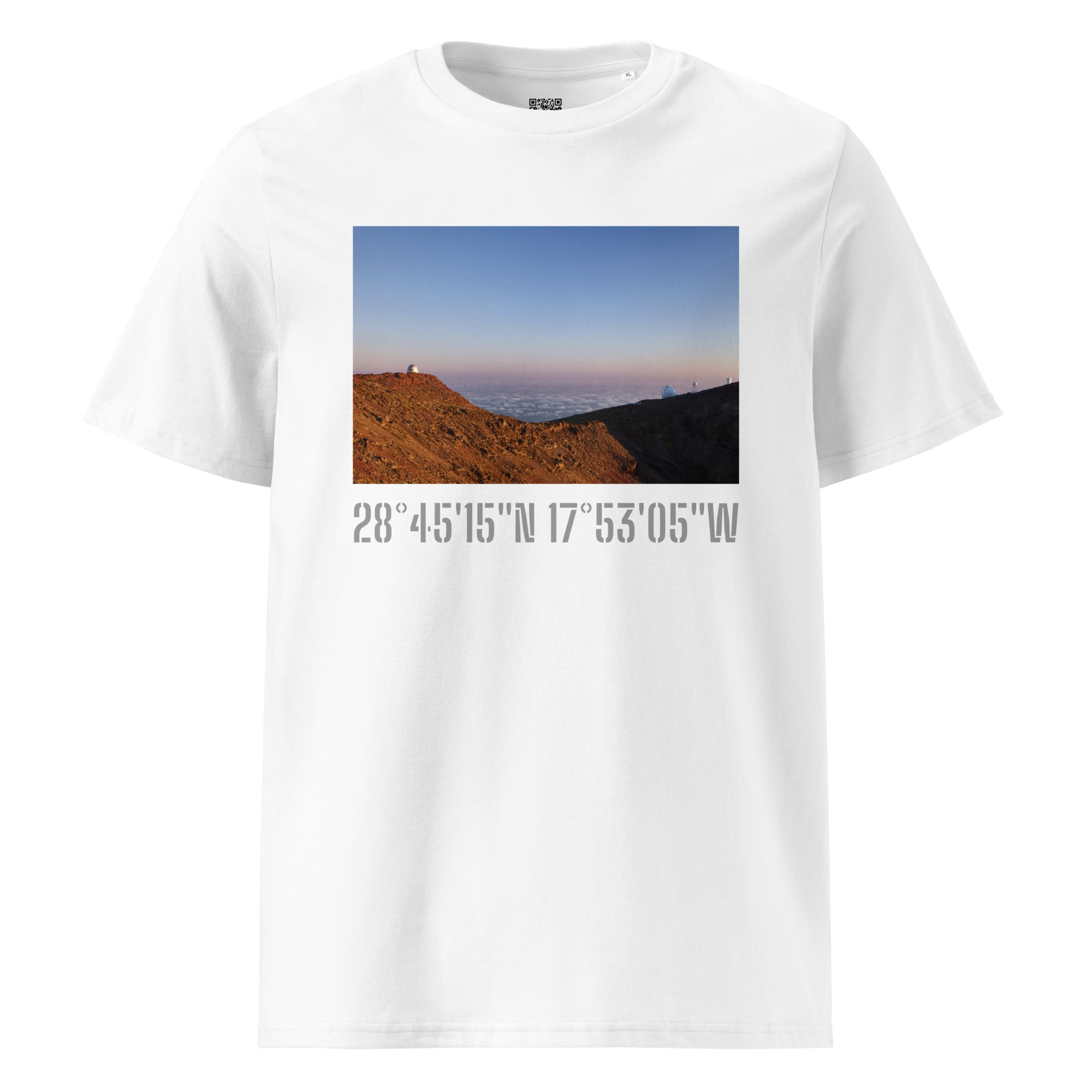 Presentamos la Camiseta unisex Telescopios del Roque de los Muchachos de Volcanica Productions, una camiseta blanca adornada con una imagen estampada de un paisaje montañoso bajo un cielo despejado. Sus coordenadas, 28°45’15”N 17°53’05”W, la conectan con La Palma.