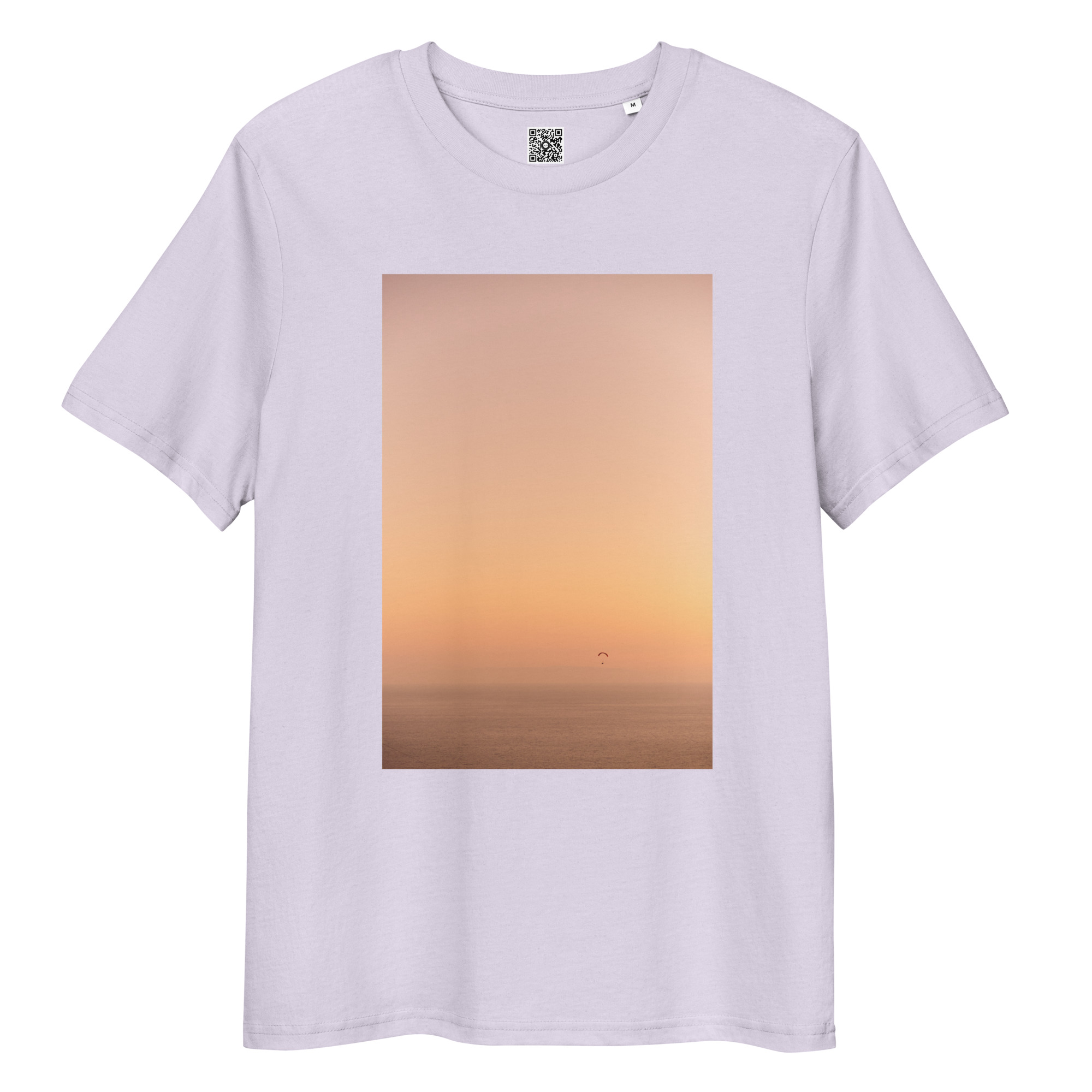 Camiseta unisex Parapente al Atardecer: presenta una imagen rectangular de un sereno atardecer sobre el mar, con el cielo cambiando gradualmente de naranja a azul pálido y la pequeña silueta de un parapente en la distancia.