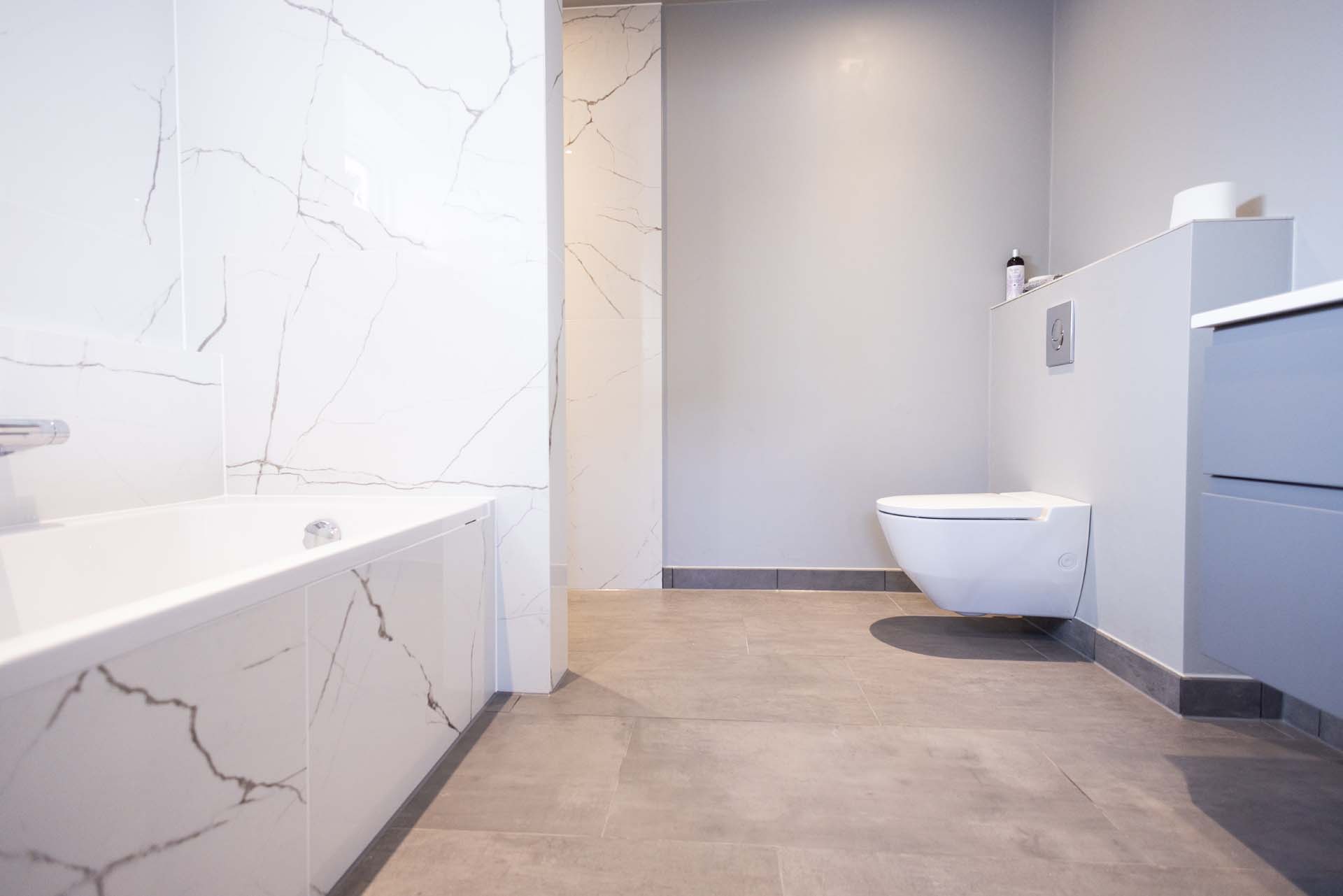 Oversigt over nyt flisegulv og væghængt toilet fra en totalrenovering af badeværelse