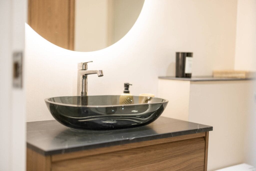 Detalje af elegant sort bowlevask på træbordplade – badeværelsesrenovering i høj kvalitet