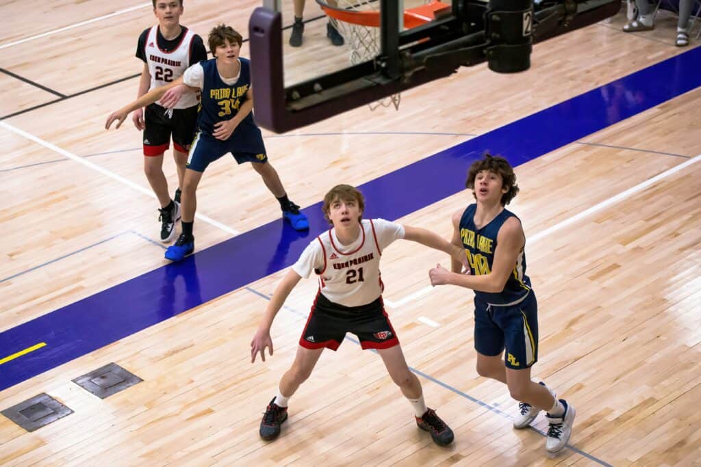 Young boys playing basketball during a youth sports game.