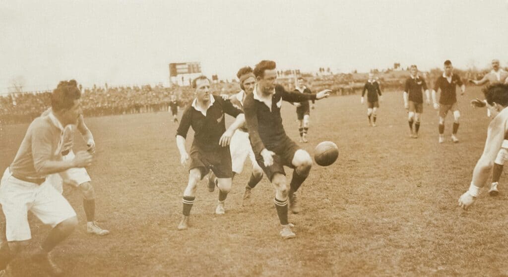 Young boys playing soccer on a vintage field during daytime.