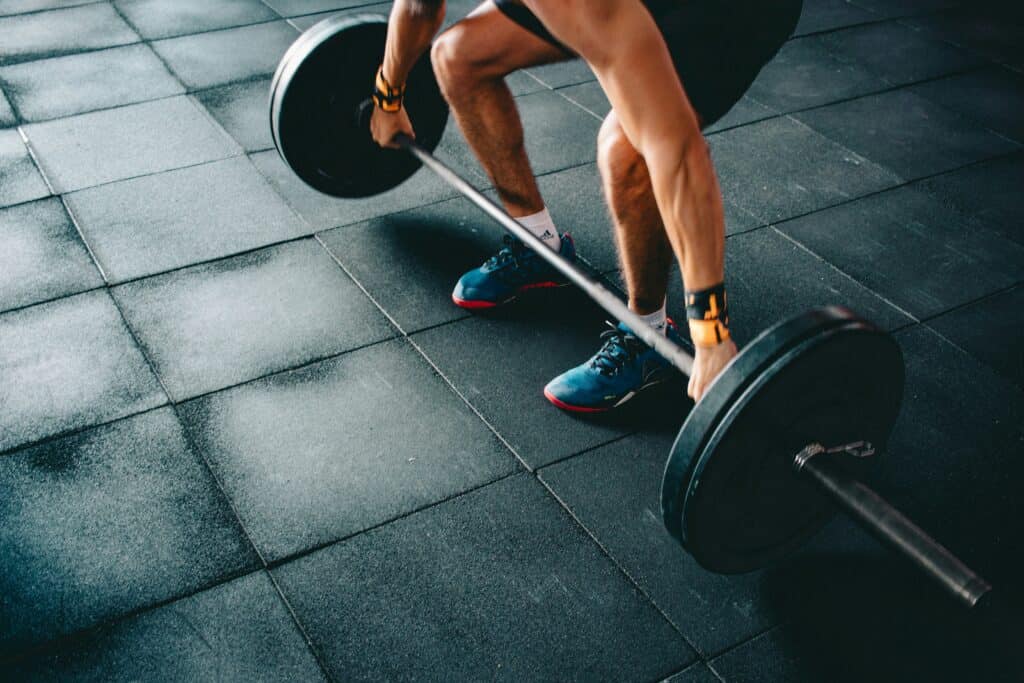 Young athlete lifting weights in gym for youth sports training.