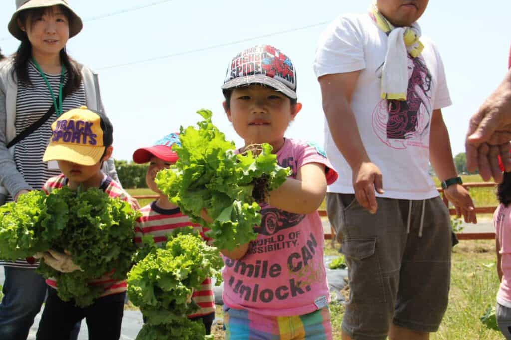 Children and adults participating in an eco-friendly community event outdoors.