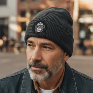 Man wearing a black GABA beanie with logo, outdoor urban setting.