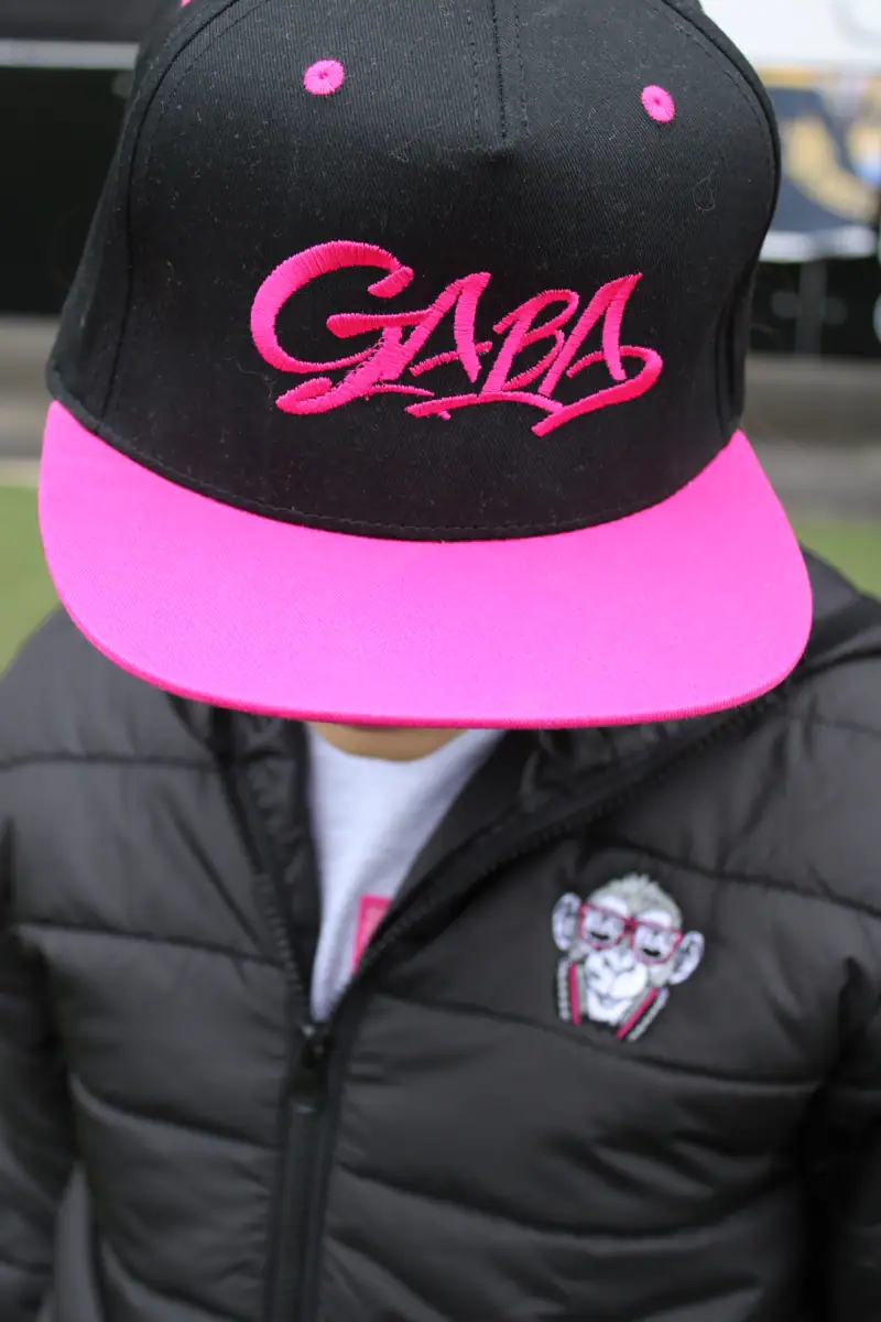 Black and pink GABA branded cap with embroidered logo, stylish headwear for casual wear.