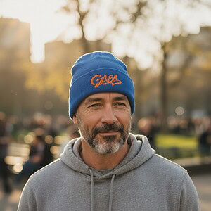 Man wearing a blue GABA beanie in an outdoor park setting.