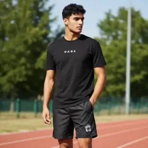 Male athlete wearing GABA Performance Tee ION-Charge on running track.