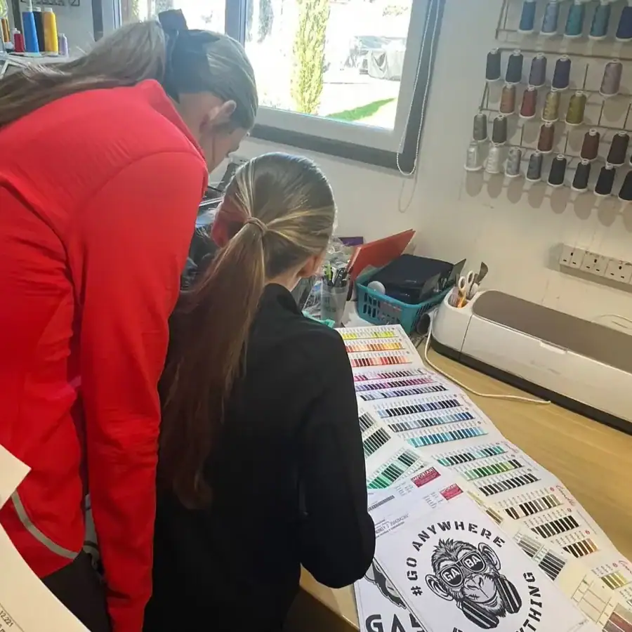 Two women examining fabric swatches in a sewing studio.