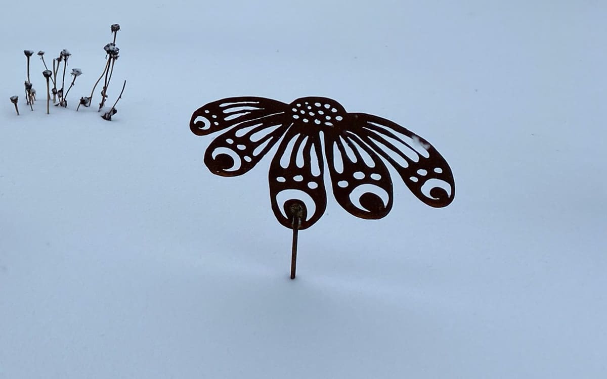 metal flower garden stake in the snow