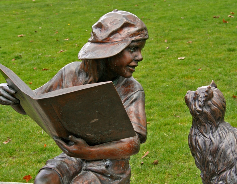boy reading garden statue